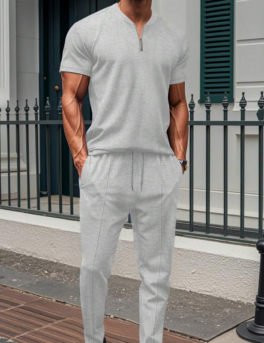 Conjunto de dos piezas para hombre con top con cuello con cremallera y pantalón con cordón y corte ajustado.